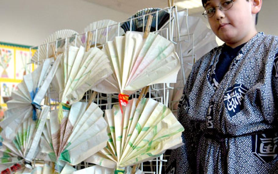 Scott Lovett, 8, wearing traditional Japanese clothing, shows off Japanese fans, some authentic and some made by members of a third-grade class.