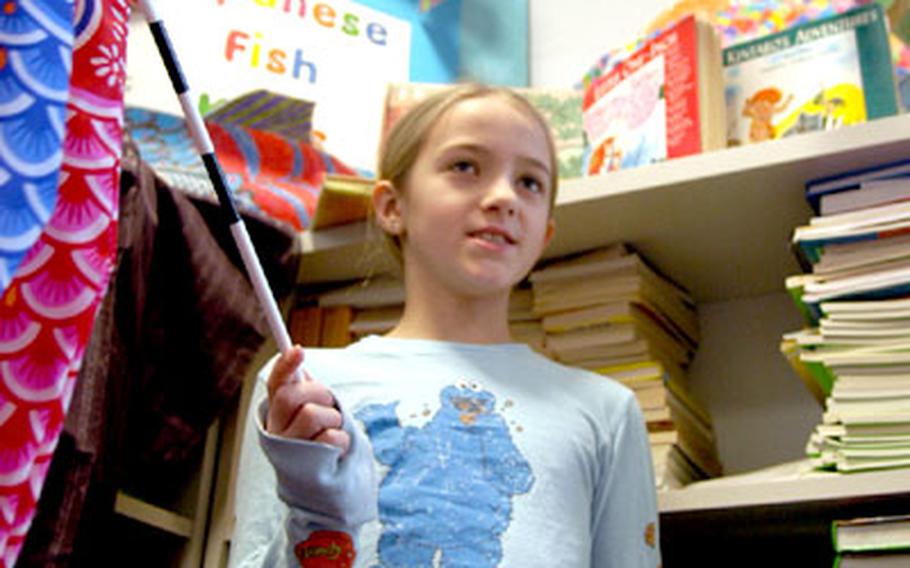 Holding a Japanese fish kite, Gracie Parrott, 8, talks about the decorative wind socks often seen around Japan.