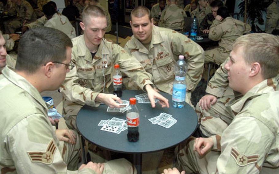 Airmen from the 31st Security Forces Squadron out of Aviano Air Base in Italy, play spades as they wait for a flight out of the RAF Mildenhall passenger terminal. On Thursday, the terminal became a hub for Air Force security forces deploying to various locations in the Central Command.