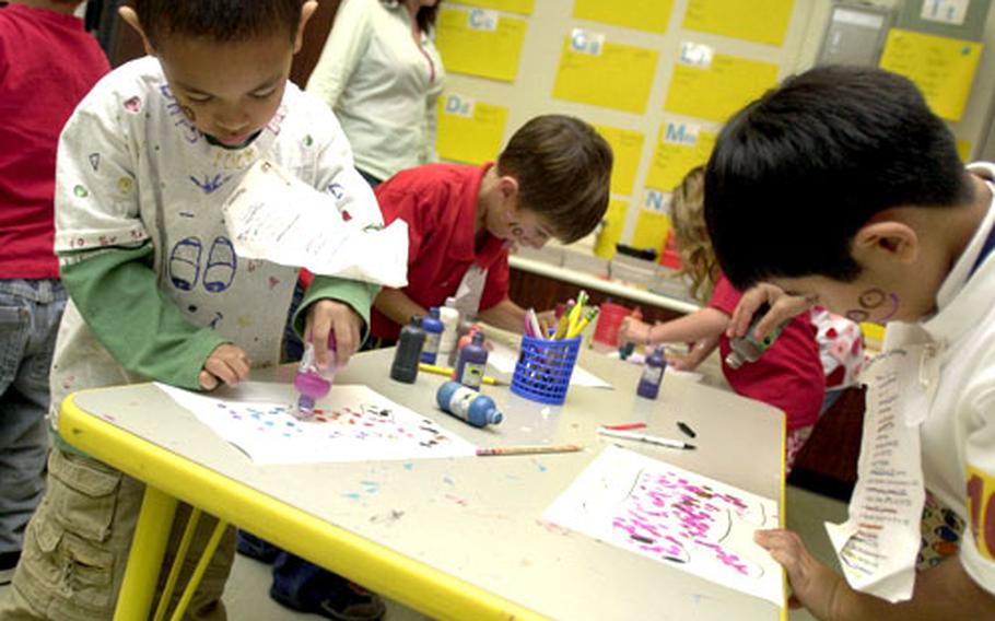 Kindergarten students stamp 100 dots onto a dog drawing.