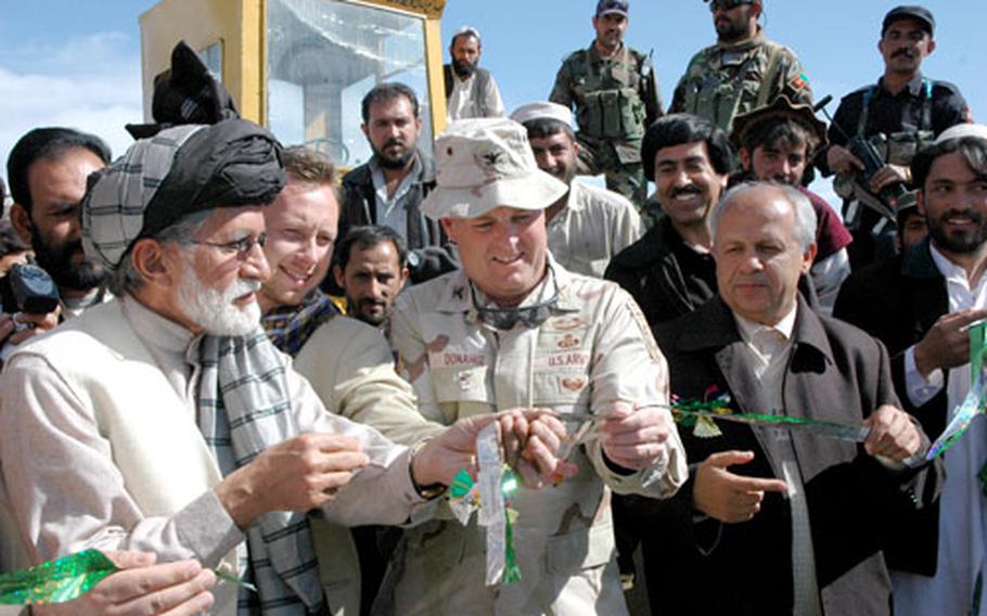 Governors Hakim Taniwal, left, and Merajuddin Patan flank Col. Pat Donahue during a ribbon-cutting ceremony marking the groundbreaking of a road that will connect the provincial capitals of Khowst and Gardez.