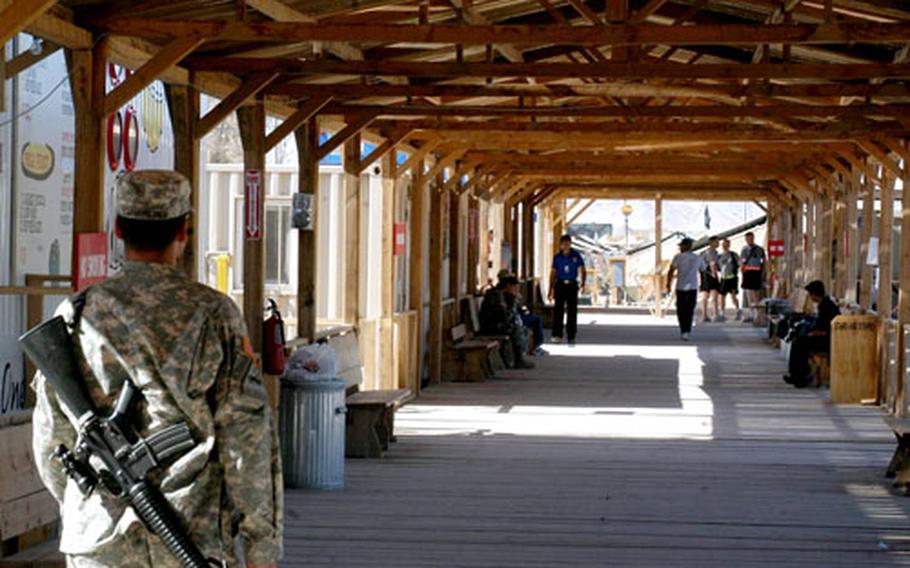 A wooden boardwalk lies at the heart of Kandahar Airfield in Afghanistan. Trailers featuring restaurants and shops line the exterior of the boardwalk, with a large open space in the interior that might one day sport athletic fields.