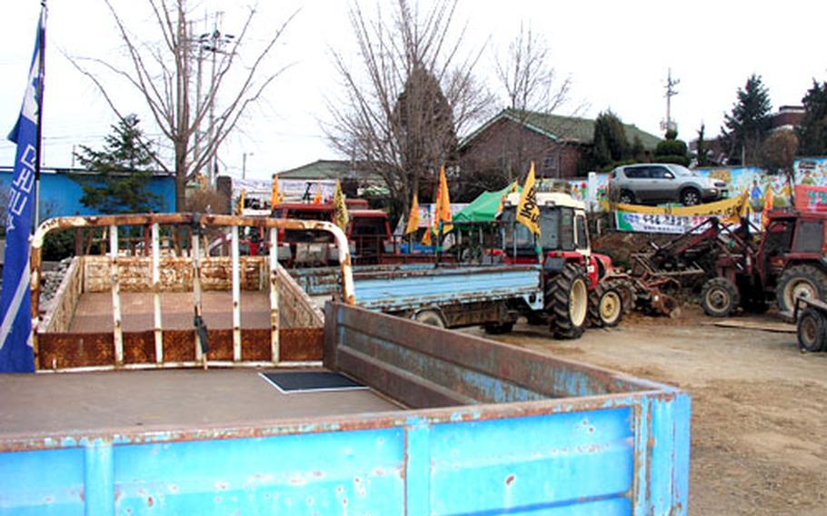 The South Korean government wants residents of the Daechu-ri farming village to move out so the U.S. military can triple the size of Camp Humphreys in coming years. The residents are using the Daechu-ri Elementary School grounds as a headquarters for their resistance. They have refused to leave their homes or vacate the school grounds. Here, vehicles and farm equipment have been put in place as a barricade behind the gate to the school.