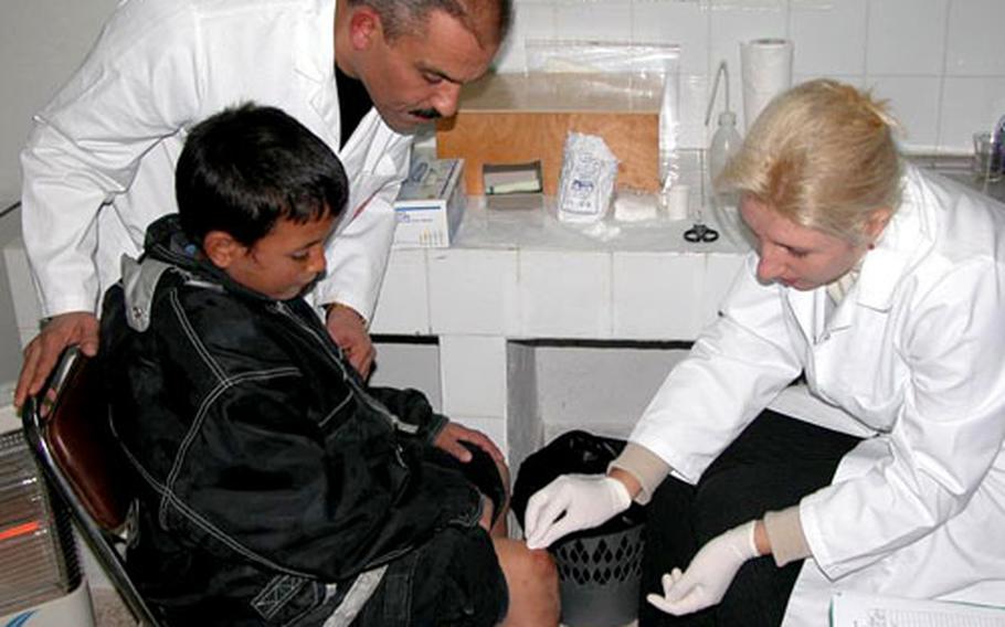 Dr. Afif Ben Saleh, left, principal investigator of a topical paromomycin trial in Sidi Bouzid, Tunisia, observes Dr. Nathalie Ben Massoud assessing a volunteer in the study. Army researchers worked with local doctors to assess the topical cream’s effectiveness on leishmaniasis.