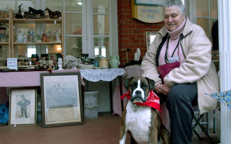 Sheila and her 6-year-old Boxer, Bonnie, watch over the collection of Churchill heads at the Newmarket Racecourse antique fair.