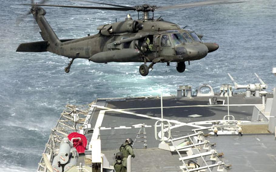 An Army UH-60 Black Hawk comes in for a landing on the back deck of the USS Curtis Wilbur during training Monday off the west coast of South Korea.