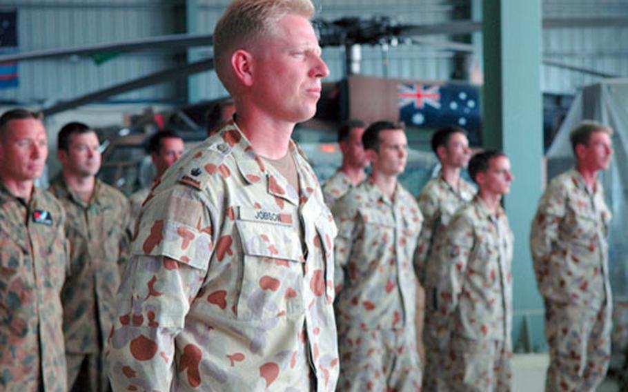 Australian soldiers stand next to an Australian BlackHawk Thursday during a ceremony marking the departure of American and Australian servicemembers from Pakistan. The Australian Army&#39;s four BlackHawks performed the majority of military personnel transportation for the relief effort.