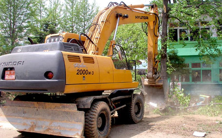 An earth-mover uproots a tree Thursday several hours before the start of demolition of the Daechu-ri Elementary School during the South Korean government’s operation to oust protesters from the school grounds. The school, near Camp Humphreys, had become a headquarters for those opposing a U.S.-South Korean plan that would see Camp Humphreys eventually become the biggest U.S. installation on the peninsula.