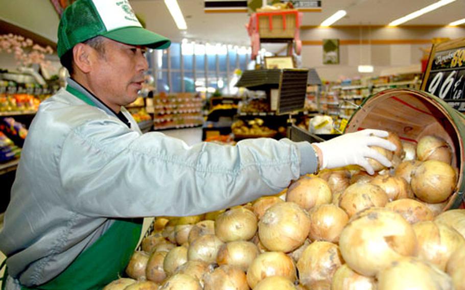 Kiyoichi Takahashi, one of 55 Japanese national employees at Misawa Air Base’s commissary in northern Japan, stacks onions Wednesday. The Defense Commissary Agency this week named Misawa as the best large commissary overseas for 2005, the second consecutive year the store has won the award.