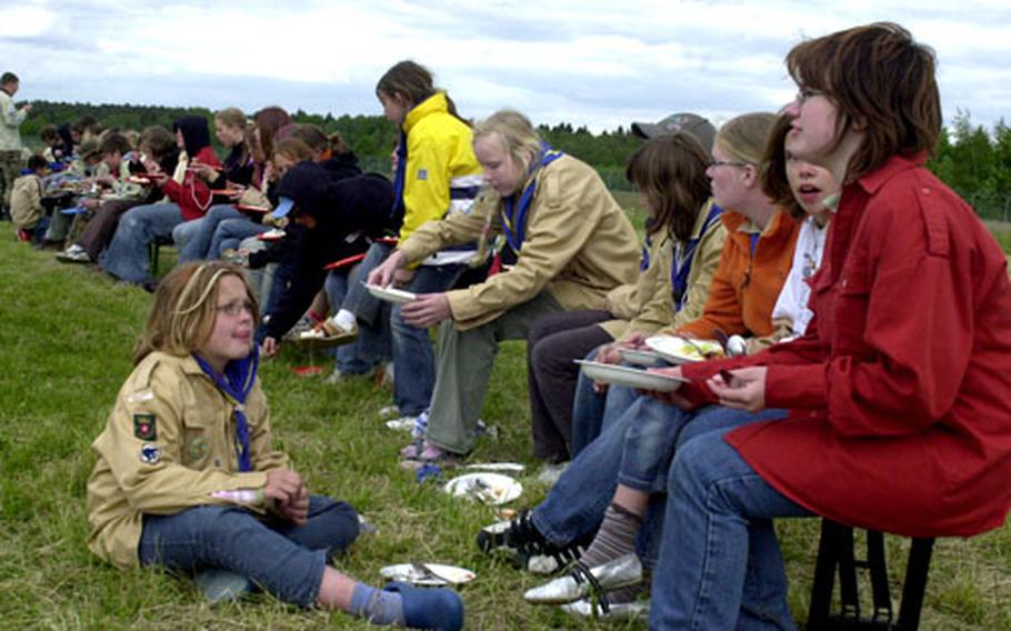 Girl Scouts participating in Intercamp 2006 enjoy an outdoor meal at Vilseck Army Airfield on Sunday.