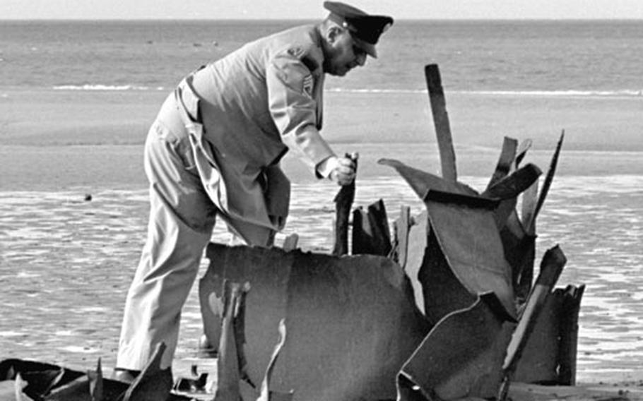 Polnoroff inspects rusting D-Day wreckage on Omaha Beach.