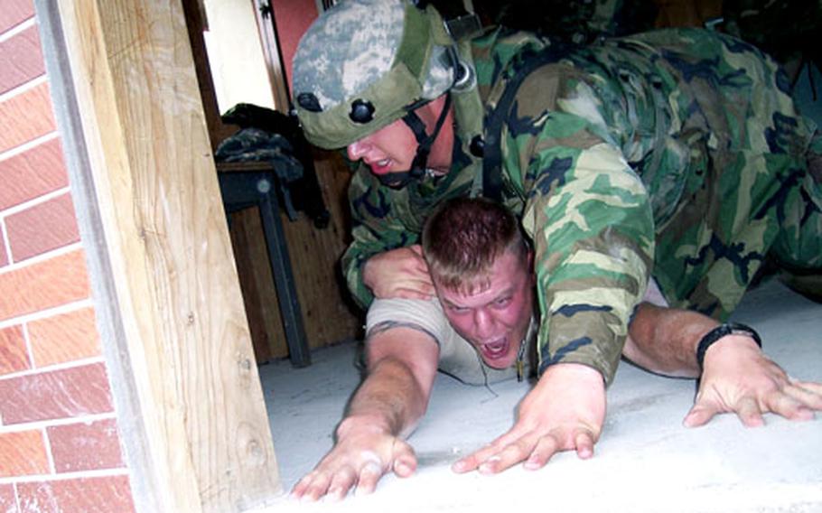 A soldier subdues mock enemy combatant Spc. Jason Gearhart during 55th Military Police Company training at Rodriguez Range, South Korea, on Thursday. The MPs spent a week practicing cordoning and searching buildings, convoy escort duties and other skills.