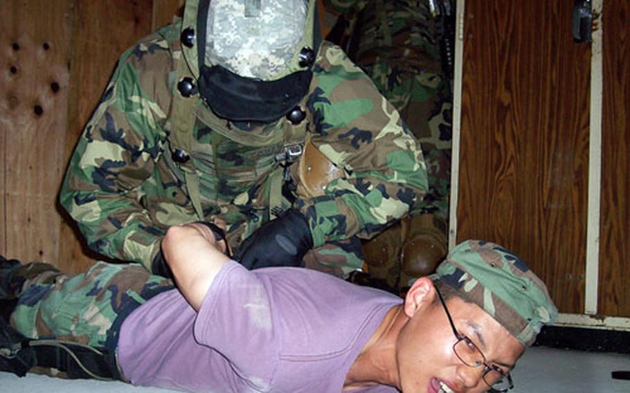 Pfc. Guillermo Fabela takes down mock enemy combatant Cpl. Lee Seung-Hoon during 55th Military Police Company training at Rodriguez Range, South Korea, on Thursday.