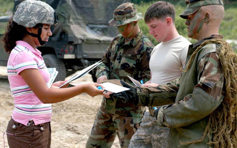 Tania Foster hands out gift certificates on May 31 to soldiers of the 2-9 sniper team.