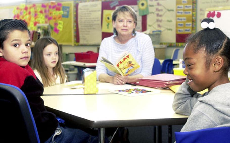 From left, first-graders Caleb Garcia, Riley McGuire and Tatiana Gatling, read about Flat Stanley with literacy coach Jacqui Gustaferro. Getting kids to love reading is nice, Gustaferro says, but real success comes when the entire family has a love of reading.