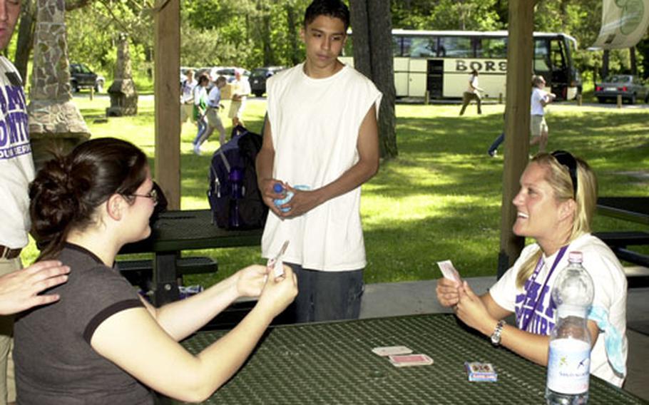 Vilseck Middle and High School student Mercedes McLaughlin, 16, left, plays cards with counselor Meg Herman, 20, of San Diego, while Würzberg American High School student Carlos Garnica, 15, watches on the first day of Camp Army Challenge at Grafenwöhr, Germany, on Sunday.