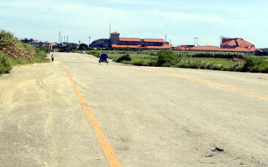 The former runway of the Yomitan Auxiliary Airfield is now a village road. In July, 346 acres of the 471-acre site will be returned. In the background is the village office complex and community center, built in 1997.