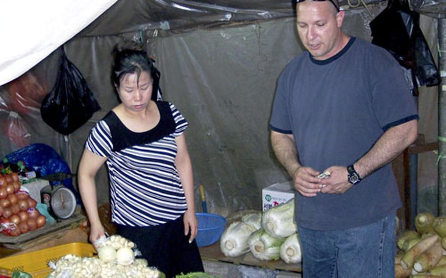 Sgt. Anthony Rocha-Arana, one of about 40 2nd Infantry Division soldiers on a Dongducheon city-sponsored tour, checks out the produce at a market on Friday.