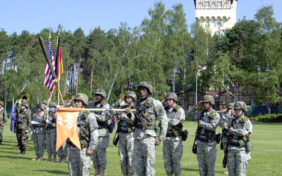 Soldiers from the 69th Signal Battalion unfurl the unit’s colors at the Grafenwöhr parade field Tuesday. The battalion is moving to Grafenwöhr from Würzburg as the base prepares for the arrival of more than 3,500 soldiers and 5,000 family members in the next two years.