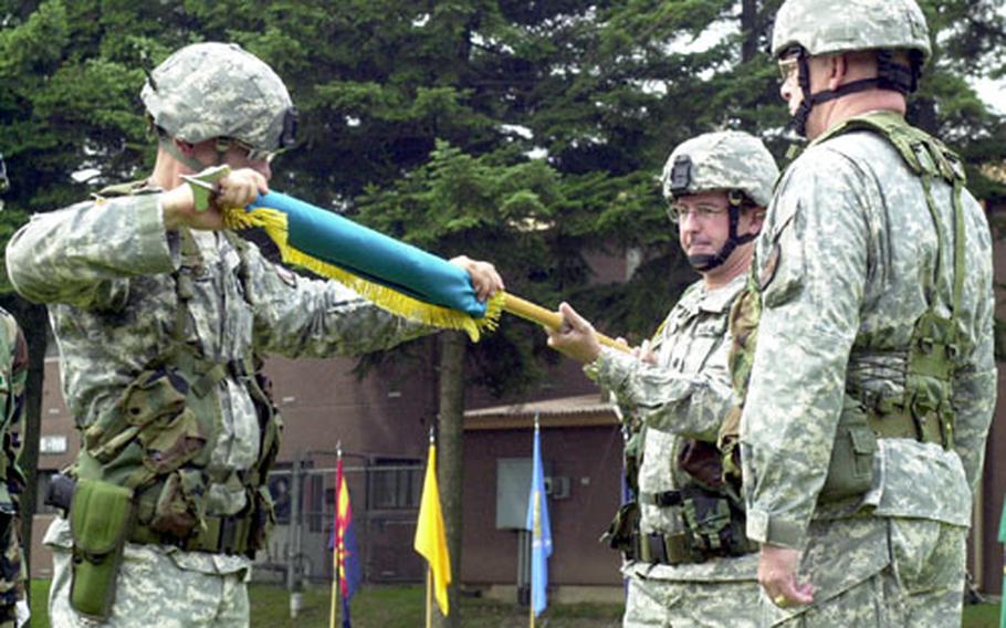 Sgt. Maj. Ricardo Soto-Acevedo, left, rolls up the United States Army Garrison Camp Red Cloud flag, along with outgoing camp commander Lt. Col. William Huber, center, and Area I commander Col. Rick Newton on Friday.