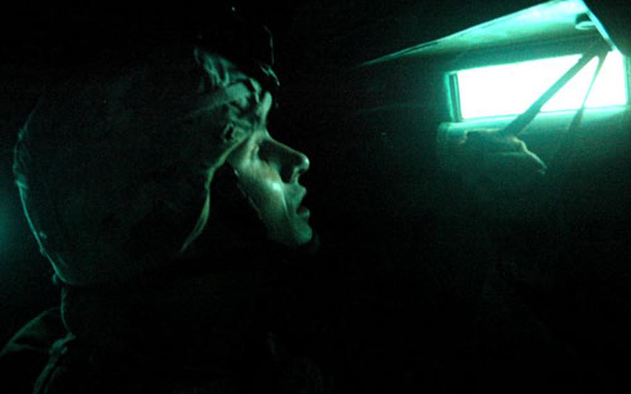 Staff Sgt. Eric Forbes, 28, of Andover, Mass., peeks through a view port in a Bradley fighting vehicle before hitting the streets of Ramadi on foot recently.