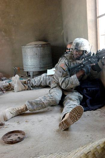 Spc. Timothy Sledge, 21, of Greenville, S.C., provides security while an interpreter translates the Friday sermon of a Ramadi mosque recently. Soldiers used a local resident’s home to monitor the speech.