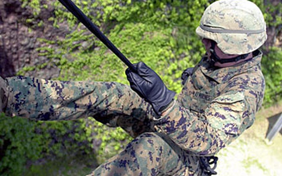 Lance Cpl. Paul Johansen, 20, from Garden City, N.J., with 3rd Materiel Readiness Battalion, steps off the lip of the skid to fast rope down to the ground 70 feet below at the Jungle Warfare Training Center Thursday.