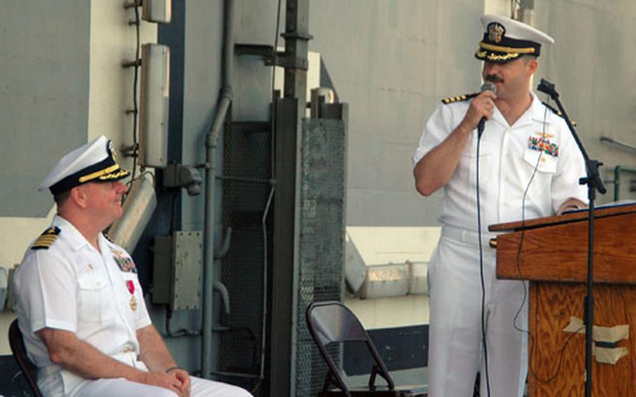 Carrier Air Wing 5 commander Capt. Michael P. McNellis, right, talks to former commander Capt. Garry R. Mace in his remarks during their change of command ceremony Sept. 2 aboard the USS Kitty Hawk off Laem Chabang, Thailand.