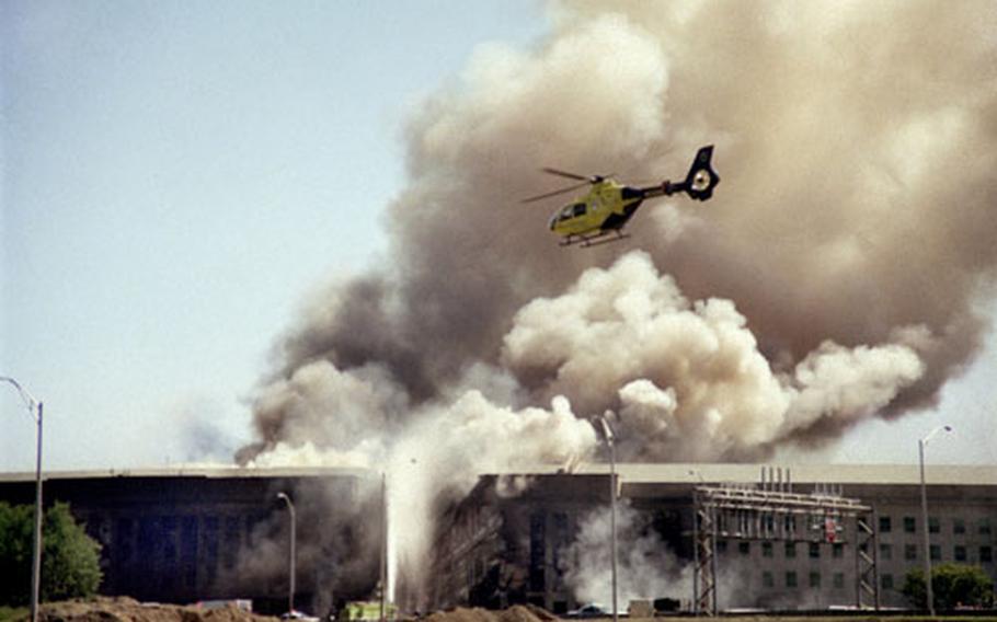 A helicopter flies over the Pentagon on Sept. 11, 2001, after terrorists crashed a hijacked airliner into the building.