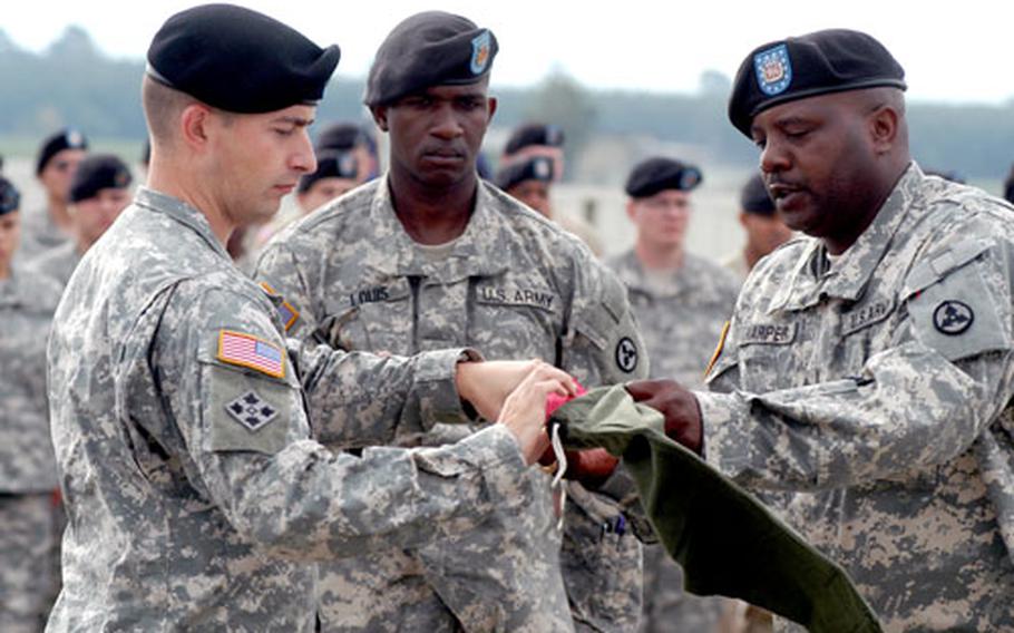 Capt. Douglas M. Sweet, left, commander of the 596th Maintenance Company, and company 1st Sgt. Darrold Harper case the company’s guidon as Spc. Richard Louis, center, holds the staff Friday during a farewell ceremony in Griesheim, Germany. The unit, based in Darmstadt, leaves for its second Iraq deployment in the next few days.