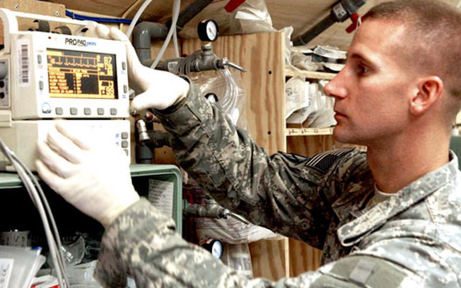 Sgt. Jason Cady checks the vital signs of a patient at the 14th Combat Support Hospital at Bagram Air Base.