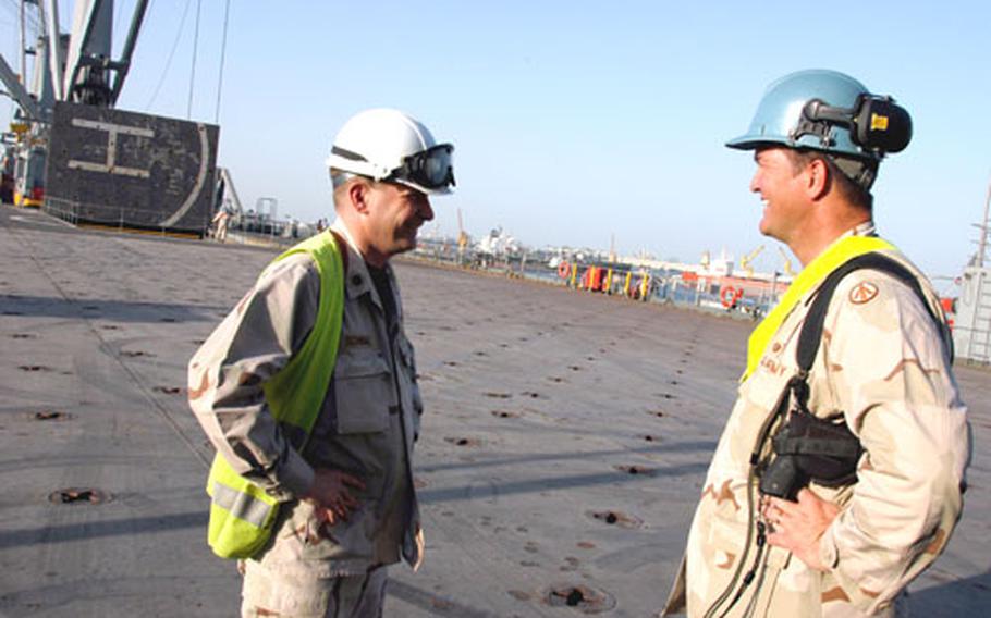 Navy Cmdr. Steve Schwing of the Naval Expeditionary Logistics Support Group, left, chats with Army Maj. David Carter, officer-in-charge of vessel terminal section, aboard the USNS Mendonca last week at Kuwait’s Sea Port of Debarkation.