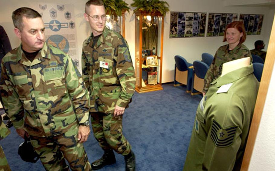 Chief Master Sgt. John Milford, left, the senior enlisted manager of the 435th Civil Engineering Squadron, and Master Sgt. Keith Custer, the first sergeant for the U.S. Forces in Europe Computer Systems Squadron, reminisce about the old green fatigue uniform on display in the new Parish Enlisted Heritage Room.