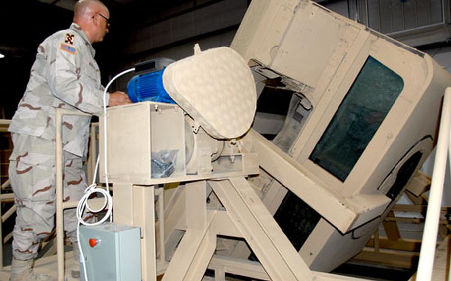 Army Lt. Col. Peter Winston, 143rd Transportation Command at Camp Arifjan, Kuwait, operates the Humvee rollover simulator as it flips upside down. The training device is made of scraps and battle-damaged Humvees and can flip 180 degrees in 6 seconds.