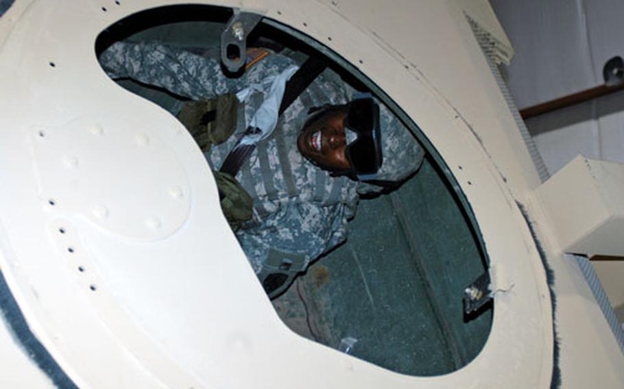 Army Sgt. Bridget Hagens, of the 3rd Personnel Command at Camp Arifjan, Kuwait, braces as the Humvee rollover simulator she’s riding tilts far to the side. About 8,000 soldiers have been trained since June in an effort to prevent injuries and death in Humvee rollovers.