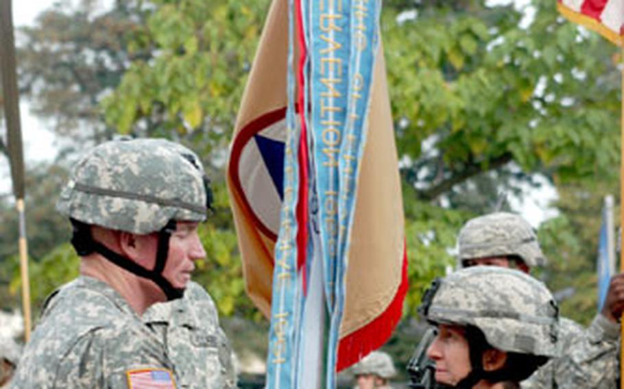 Army Brig. Gen. Scott G. West, left, and Brig. Gen. Becky Halstead take part in the traditional passing of the unit guidon during her change of command ceremony Thursday in Wiesbaden, Germany.