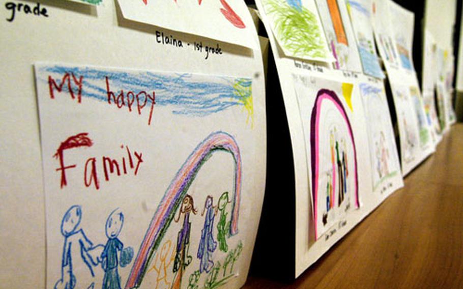 Posters depicting children’s ideas of healthy and happy homes line the walls of the community center at Naval Support Activity Naples, Italy, for Tuesday’s candlelight vigil.