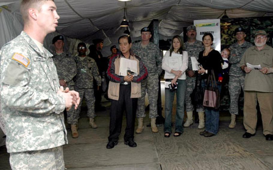 Military civilian workers and dependents listen to a briefing Friday during a semi-annual evacuation training exercise. Among the listeners is Gen. B. B. Bell, commander of U.S. Forces Korea.