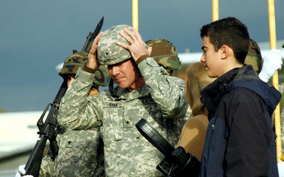 The 1st Armored Division’s newest one star, Brig. Gen. Michael A. Ryan, puts on his Kevlar reflecting his new rank as son Sean watches during a ceremony Friday at the Wiesbaden Army Airfield, Germany.