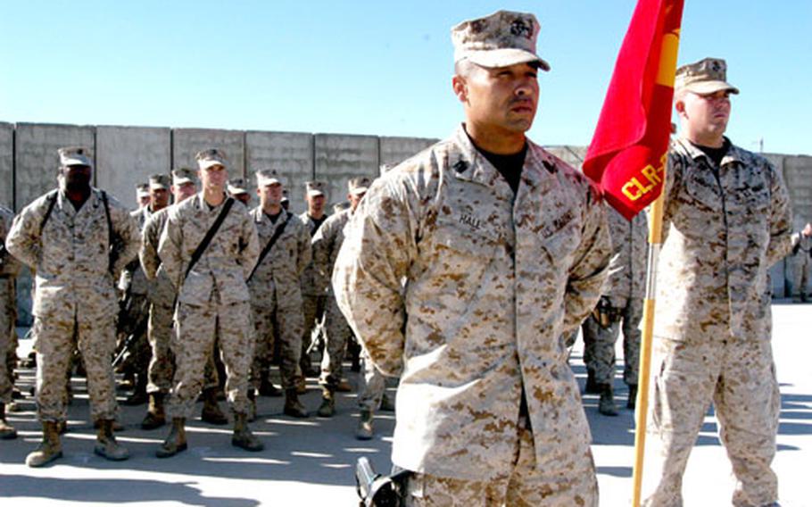 First Sgt. Barry R. Hall, center, and Cpl. Robert L. Landsperger, right, stand with Headquarters Company, 1st Marines Logistics Group, during the celebration of the 231st birthday of the U.S. Marine Corps at Camp Taqaddum, Iraq.