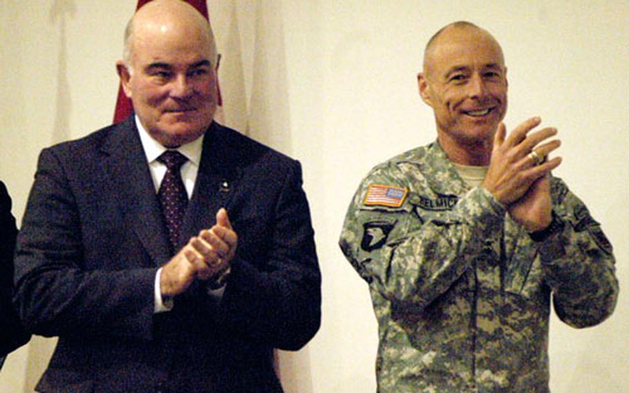 Secretary of the Army Francis Harvey, left, and Maj. Gen. Frank Helmick, commander of the Southern European Task Force (Airborne), lead the clapping as three soldiers are sworn in as citizens in the base theater Monday. Harvey addressed SETAF troops’ concerns and discounted suggestions that the Army is being stretched too thin.