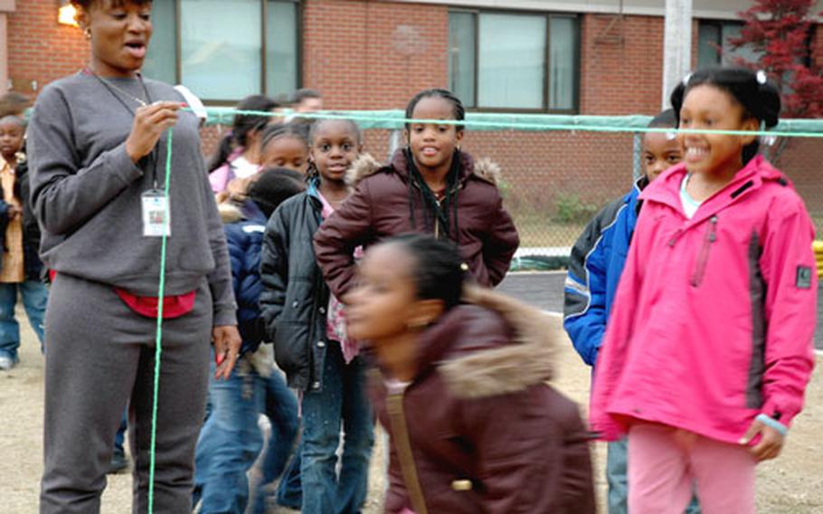 Children do the limbo outside the Child and Youth Services building on Yongsan Garrison Tuesday afternoon during the School-Age Services program. This before- and after-school program offers services for USFK families in which both parents work.