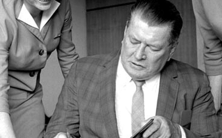 Gene Tunney meets with reporters and signs autographs at the Frankfurt airport in November, 1965.