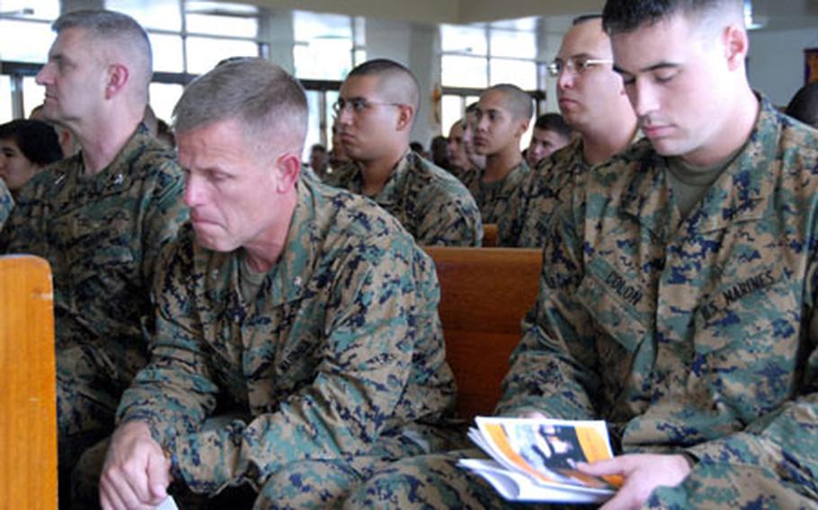 Lance Cpl. Stephen Colon(right) listens to "Amazing Grace" being played on the bagpipes at a memorial service Tuesday for Cpl. Jennifer Parcell, who was killed in Iraq last week.