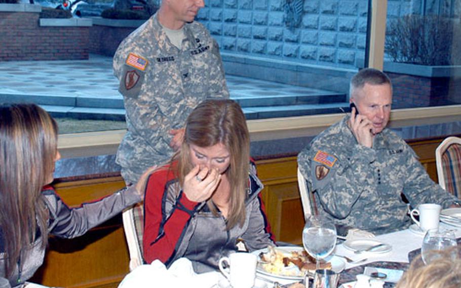 Tampa Bay Buccaneers cheerleader Aubrey Gainey, center, wipes away tears as U.S. Forces Korea commander Gen. B. B. Bell talks to her brother, Sgt. Cole Gainey, who was wounded in Iraq and is recovering at Fort Carson, Colo.