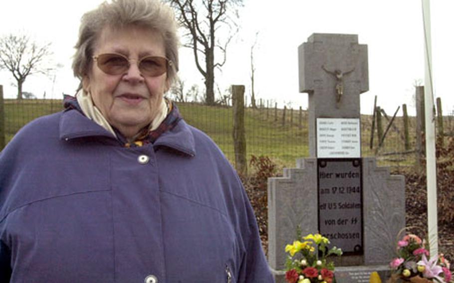 Tina Langer, whose father sheltered 11 black American soldiers during World War II before German soldiers massacred them, stands in front of the Wereth 11 Memorial in Wereth, Belgium.