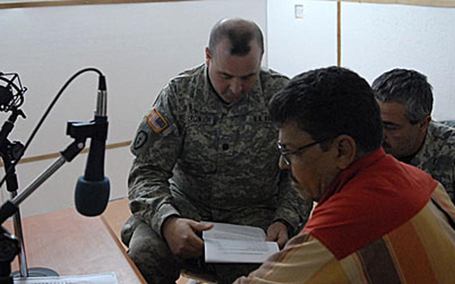 Lt. Col. Drew Meyerowich, the commanding officer at Forward Operating Base McHenry, prepares to go on the air at a radio station near Hawijah.