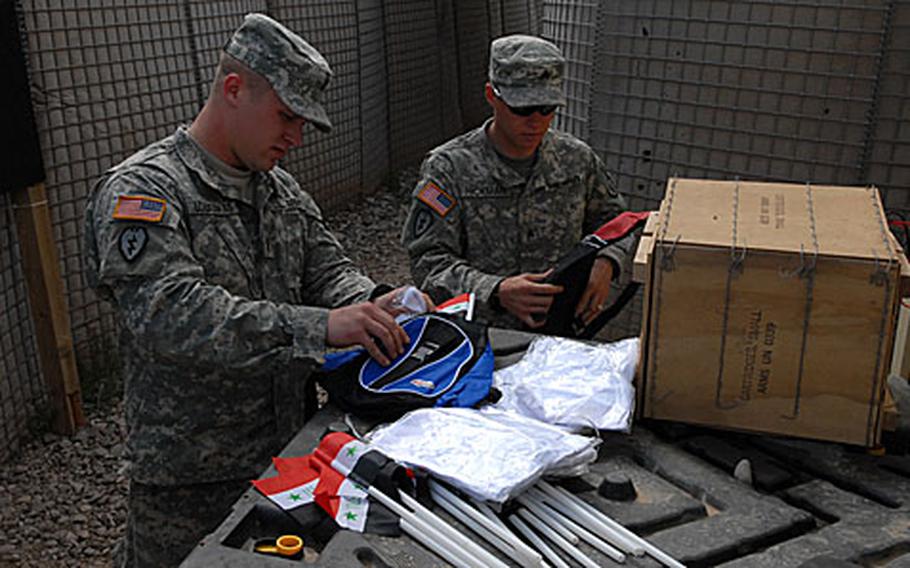 First Lt. Gerald Lozauskas (left), a platoon leader with the 2nd Battalion, 27th Infantry, and Sgt. Andrew "Helium" Hickman prepare care packages for residents of Hawijah on Feb. 25 as part of an effort of community outreach to turn public opinion in favor of coalition forces.