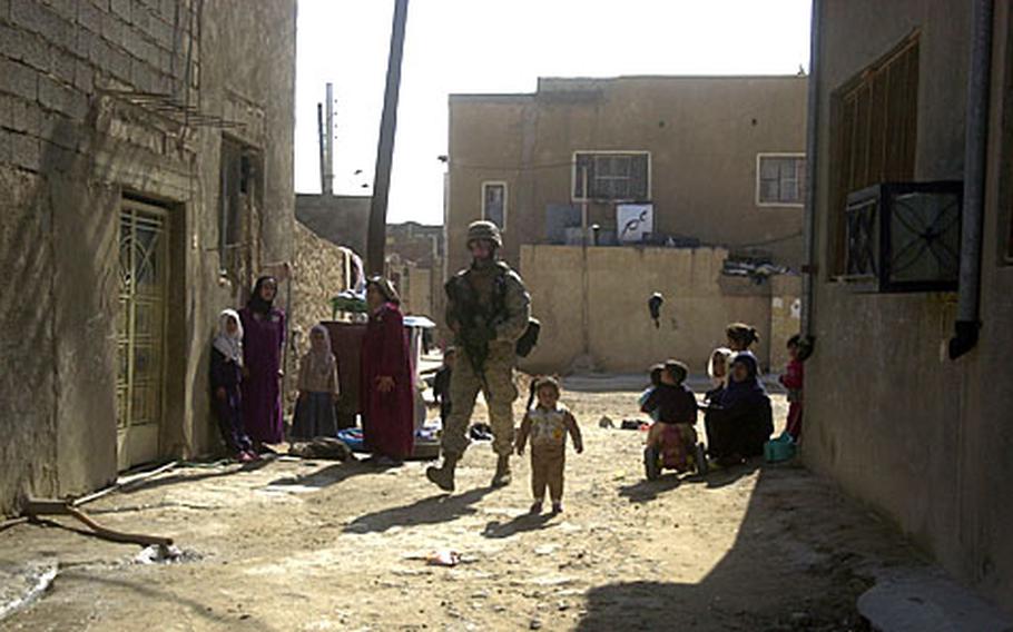 A Marine with 2nd Battalion, 3rd Marine Regiment patrols through a maze of streets and alleys in Haqlaniyah, Iraq. The battalion has adapted from the mountainous, rural landscape of Afghanistan to the flat, urban environment of Iraq.