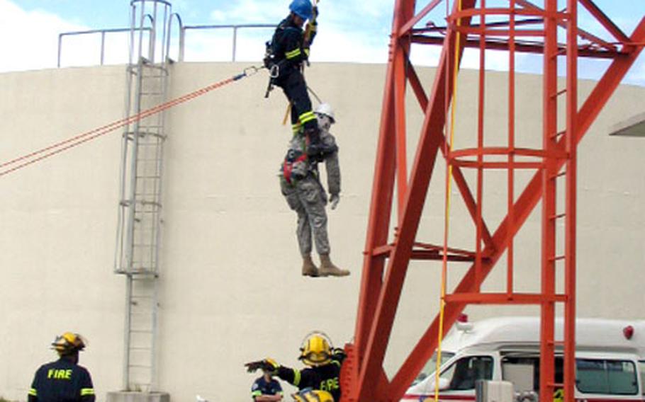 Firefighter Diaki Kawabata eases a "victim" down from a communications tower.